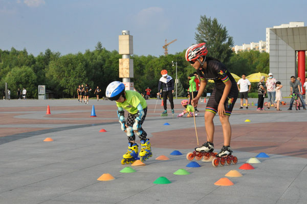 8月12日,肇东一名小学生正在教练的指导下进行轮滑训练.